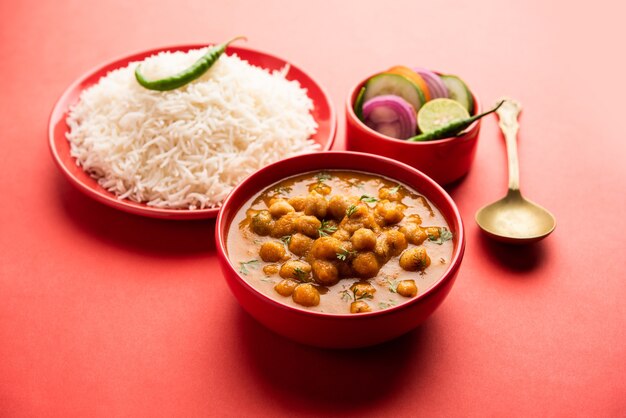 Indyjskie jedzenie chole chawal lub pikantne curry z ciecierzycy z ryżem zwykłym podawane z zieloną sałatą. selektywne skupienie