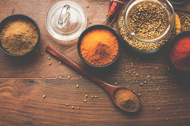 Indyjskie kolorowe przyprawy. Zdjęcie grupowe czterech podstawowych indyjskich przypraw, takich jak surowe czerwone chili, kurkuma, kolendra i kminek w proszku. selektywne skupienie