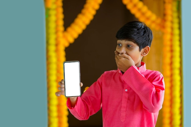 Indyjskie małe dziecko w tradycyjnym stroju i pokazujące smartfona