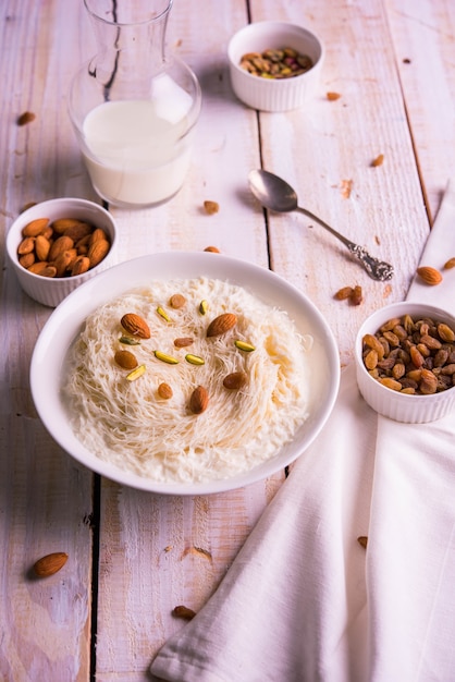 Indyjskie słodkie sutarfeni lub sutar feni lub firni lub seviyan lub laccha, posiekana, łuszcząca się mąka ryżowo-ryżowa prażona w ghee, zmieszana z roztopionym cukrem w celu uzyskania waty cukrowej, posypana pistacjami i migdałami