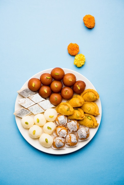 Indyjskie słodycze na talerzu to Gulab Jamun, Rasgulla, kaju katli, morichoor lub Bundi Laddu, Gujiya lub Karanji na obchody diwali