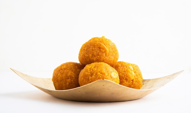 Indyjskie tradycyjne słodycze Diwali zwane Motichoor Ladoo lub bundi laddu w kwadratowej mosiężnej płycie, zbliżenie i przedni kąt