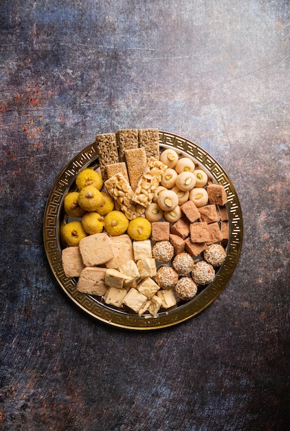 Indyjskie tradycyjne słodycze laddu gulab jamun soan papdi burfi na festiwal na betonowym tle z miejscem na kopię płasko leżał