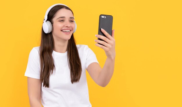 Influencer blogujący szczęśliwa śmiejąca się dziewczyna w słuchawkach webinar w bezprzewodowym zestawie słuchawkowym