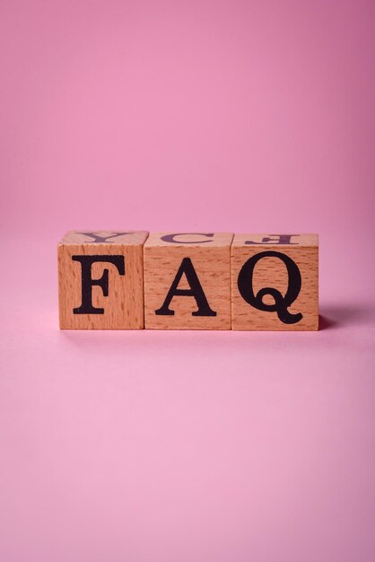 Inskrypcja FAQ składająca się z drewnianych kostek na zwykłym tle