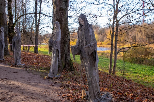 Zdjęcie instalacja wielu przerażających postaci demonów w parku w dzień halloween