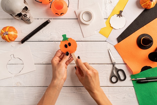 Instrukcja krok po kroku tworzenia zakładek na halloween DIY dyniowe rzemiosło. Krok 6 - przyklej dynię i patyczek do lodów. Zakładka jest gotowa