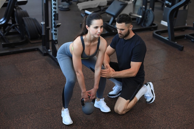 Instruktor Fitness ćwiczący Ze Swoim Klientem Na Siłowni.