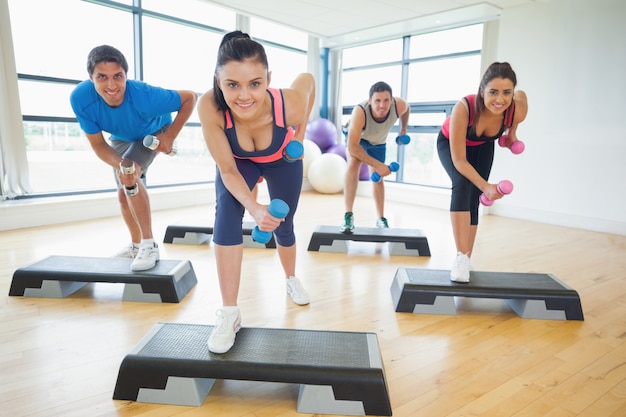 Instruktor klasy fitness wykonujący ćwiczenia aerobowe z hantlami