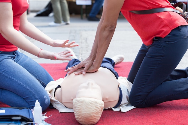 Zdjęcie instruktor wyjaśnia pracownikowi ratowniczemu podczas wykonywania cpr na manekinie