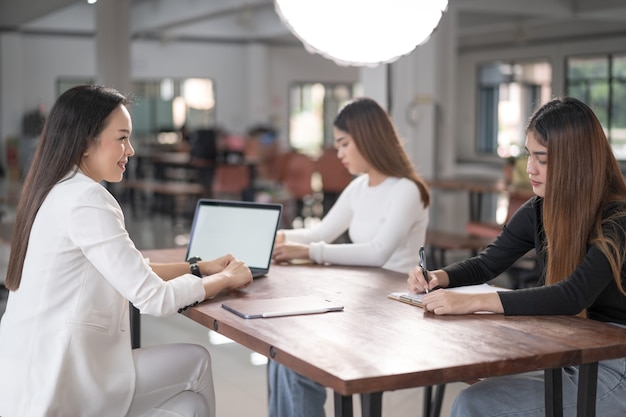 Instruktorzy i doradcy szkół wyższych spotykają się ze studentkami, aby doradzić im w swoich badaniach. Koncepcja edukacji Stock Photo