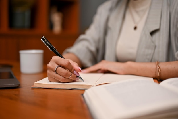 Inteligentna Azjatycka Bizneswoman Pisze Coś Na Swoim Notatniku Podczas Pracy W Swoim Biurze