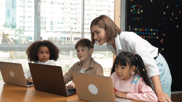 Inteligentny nauczyciel uczy i wygląda na ucznia korzystającego z laptopa w klasie Erudycja