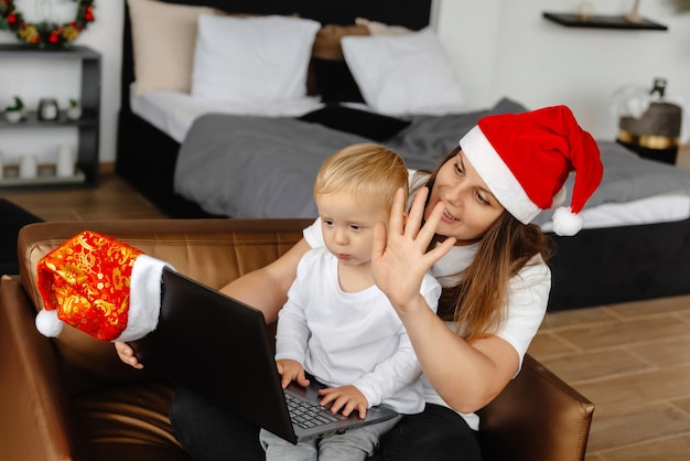 Internetowa matka i syn machają do swoich krewnych przez rodzinę z aparatem w laptopie siedzącą we fr