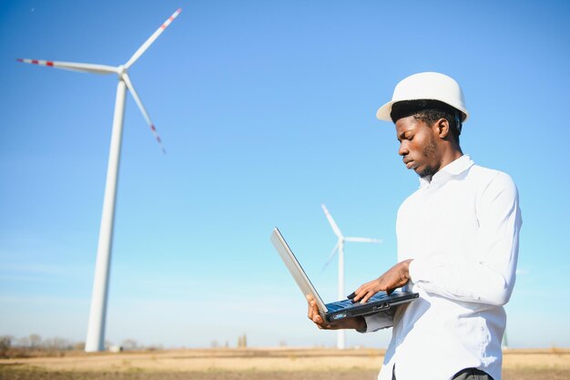 Inżynier afrykański mężczyzna stojący z turbiną wiatrową