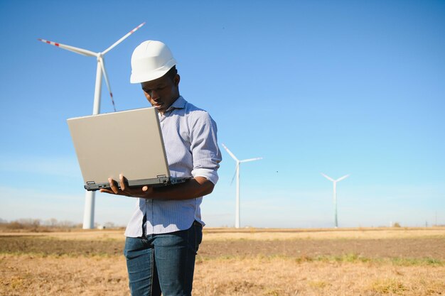 Inżynier afrykański mężczyzna stojący z turbiną wiatrową