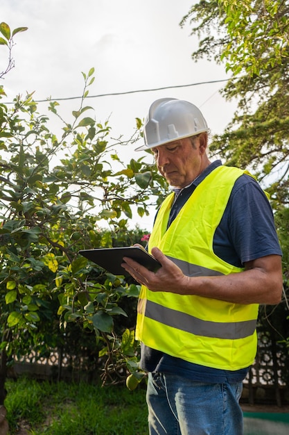 Zdjęcie inżynier agronom trzyma w dłoniach tablet i patrzy na urządzenie