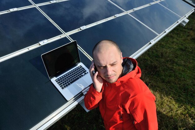 inżynier biznesu korzystający z laptopa przy panelach słonecznych roślina eko pole energii w tle