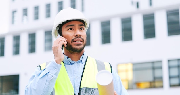 Inżynier budownictwa podczas rozmowy telefonicznej na placu budowy, omawiający strategię i plan pracy Zbliżenie portret pewnego architekta rozmawiającego z budynkiem w tle i miejsca na kopię