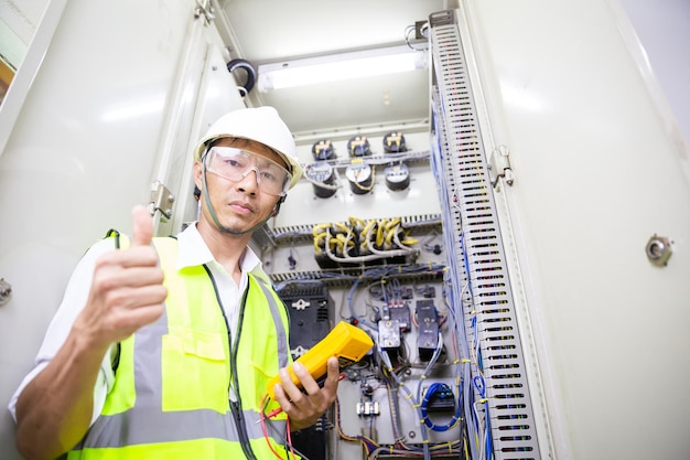 Inżynier elektryk pracuje w systemie zabezpieczeń przekaźnika. Jednostka sterująca pola. Rozdzielnica średniego napięcia.