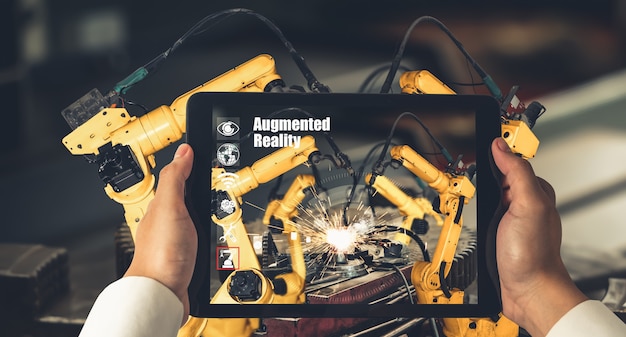 Inżynier kontroluje ramiona robotów za pomocą technologii przemysłowej rozszerzonej rzeczywistości