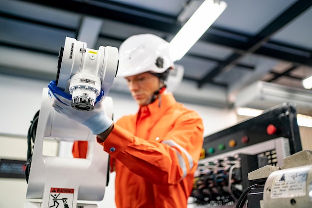 Zdjęcie inżynier mężczyzna pracujący przy robocie przemysłowym w fabrycznej robotyce przemysłowej i cyfrowej produkcji