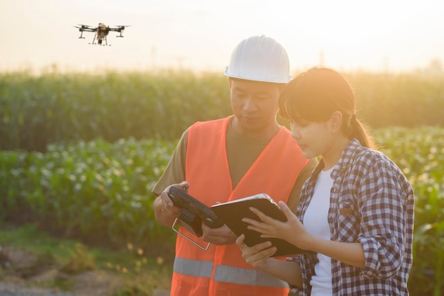 Inżynier-mężczyzna udziela konsultacji i instruuje inteligentnego rolnika z opryskiwaniem dronem
