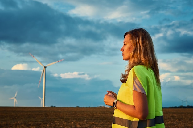 Zdjęcie inżynier obserwuje turbiny wiatrowe w terenie, konserwację generatorów wiatrowych, zieloną energię odnawialną