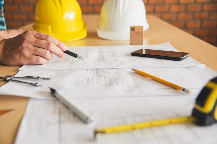Inżynier pracujący w biurze z planami, inspekcja w miejscu pracy dla planu architektonicznego, projekt budowlany, budowa biznesu.