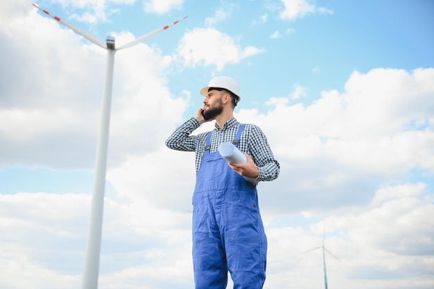 Inżynier sprawdza produkcję energii na turbinie wiatrowej Pracownik w parku wiatraków