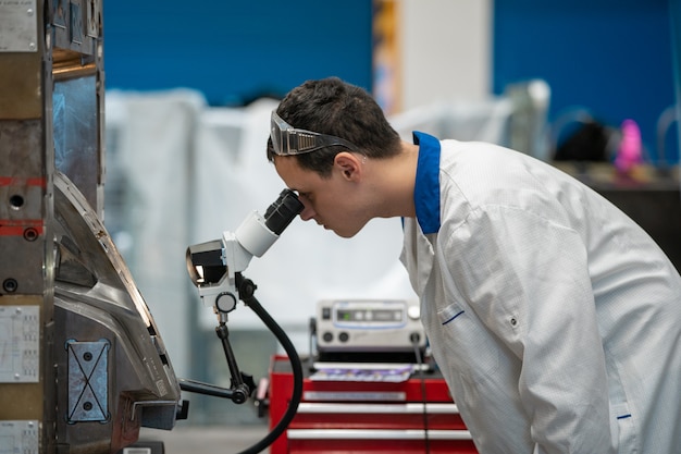 Inżynier Sprawdza Za Pomocą Mikroskopu Prawidłowe Ustawienie Metalowej Formy Do Odlewów W Fabryce