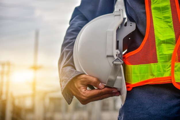 Inżynier trzyma ciężkiego kapeluszu pracownika budowlanego fachowego bezpieczeństwa pracy przemysłu budynku osoby kierownika usługa
