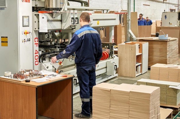 Zdjęcie inżynier w fabryce mebli przemysłowych kontroluje jakość produktów. nowoczesna produkcja mebli przemysłowych.