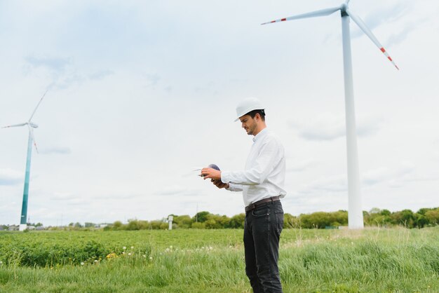 Inżynier w kasku pracujący na farmie turbin wiatrowych