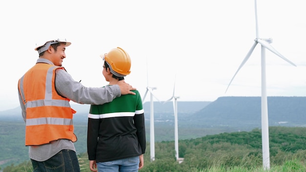 Inżynier z synem na farmie wiatrowej na szczycie wzgórza lub góry na wsi Progresywny ideał dla przyszłej produkcji odnawialnej energii zrównoważonej Generowanie energii z turbiny wiatrowej