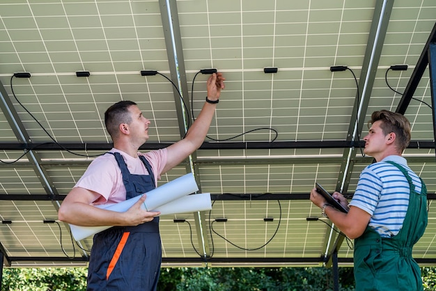Inżynierowie elektrycy badający konstrukcję w pobliżu baterii słonecznych zielona energia