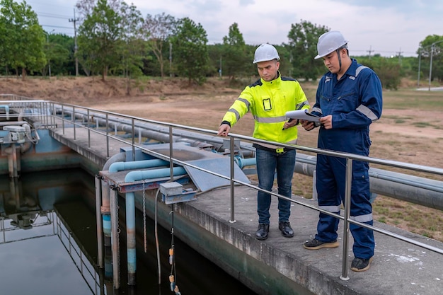 Inżynierowie ochrony środowiska pracują w oczyszczalniach ściekówInżynieria zaopatrzenia w wodę pracują w Zakład recyklingu wody do ponownego wykorzystania Technicy i inżynierowie rozmawiają o współpracy
