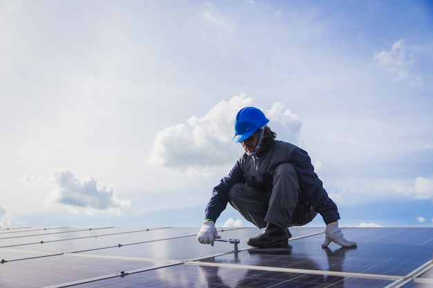 Inżynierowie pracujący i sprawdzający wytwarzają energię elektrowni słonecznej na dachu słonecznym