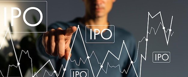 IPO - koncepcja pierwszej oferty publicznej z ręcznym naciśnięciem przycisku na niewyraźnym tle abstrakcyjnym.