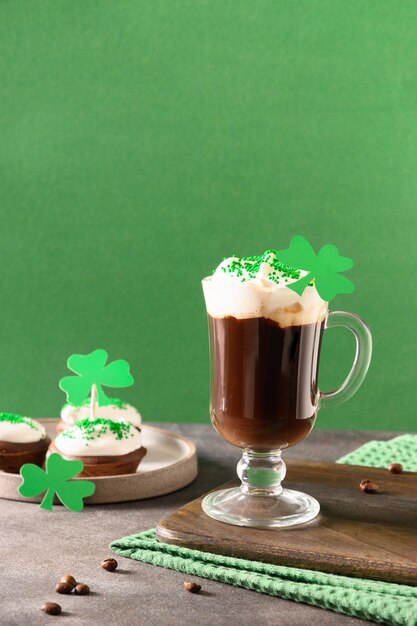 Zdjęcie irlandzka kawa w zielonej filiżance i specjalne babeczki na dzień świętego patryka