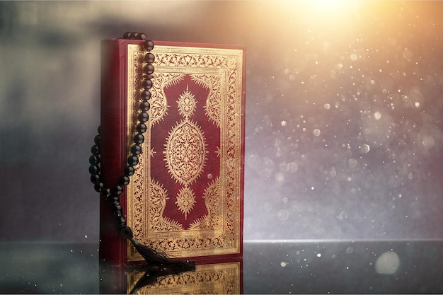 Zdjęcie islamska księga koran z różańcem na tle