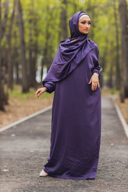 Islamska piękna kobieta w muzułmańskiej sukience stojącej na tle ulicy lato park las jesień drzewa. Świat hidżab dzień.