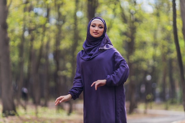 Islamska piękna kobieta w muzułmańskiej sukience stojącej na tle ulicy lato park las jesień drzewa. Świat hidżab dzień.