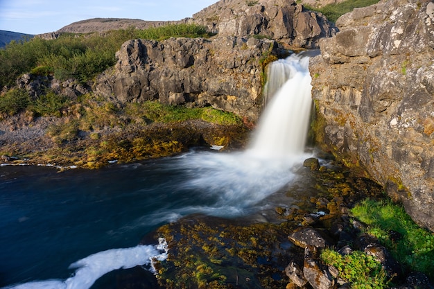 Islandia wodospad zbliżenie widok klifu bogów z długą ekspozycją płynny ruch wody w letni krajobraz.