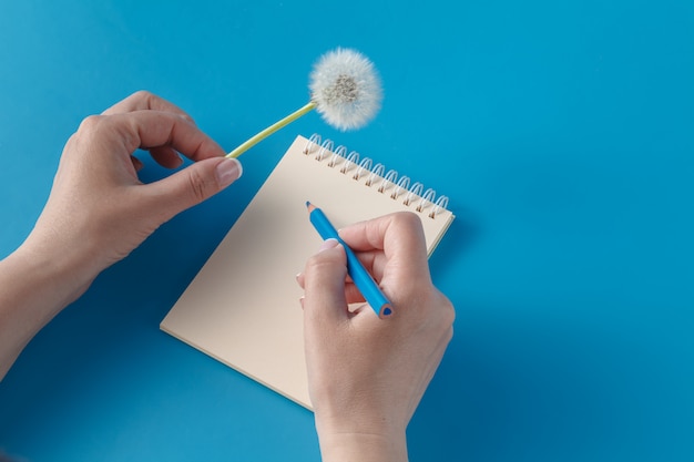 Istot ludzkich ręki z ołówkowym writing na papierze