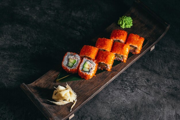 Zdjęcie izolowane sushi i bułki na ciemnym, kontrastowym tle formatu menu