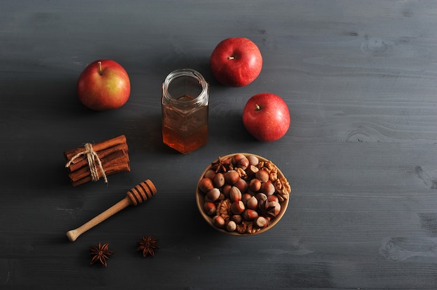 jabłka, miód i orzechy na ciemnym stole