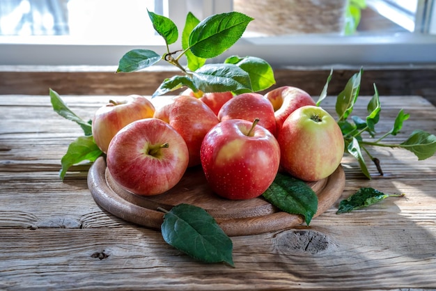 Jabłka z liśćmi na drewnianym stole