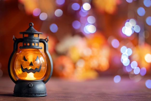 Jack o lantern Halloween dynia twarz w latarni jesienią kolorowe tło ze światłami bokeh i jesiennymi liśćmi