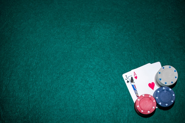 Zdjęcie jack of spade i serce as karta z żetonami na zielonym stole pokerowym